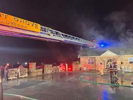 Ladder 22's crew operates on the roof of this New Garden Township business whose attic and second floor were damaged by fire on Tuesday.